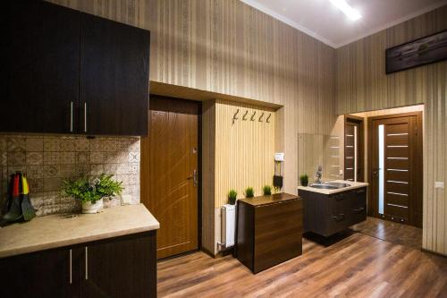 una cucina con pavimenti in legno e una cucina con lavandino di Baker's street a Lviv