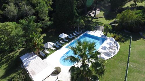 uma vista sobre uma piscina com cadeiras e árvores em Las Ardillas Cabañas y Suites em La Falda
