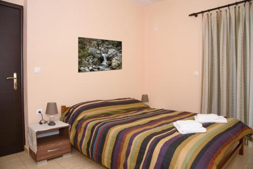 1 dormitorio con 1 cama y 1 mesa con lámpara en House Evia en Strópones