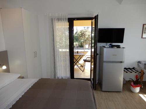 sypialnia z łóżkiem i drzwiami na taras w obiekcie Apartments Simicev w mieście Zadar