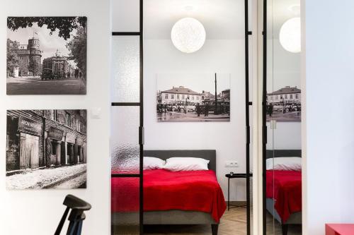 1 dormitorio con cama roja y algunos edificios en apartamenty Stary Kraków GO, en Cracovia