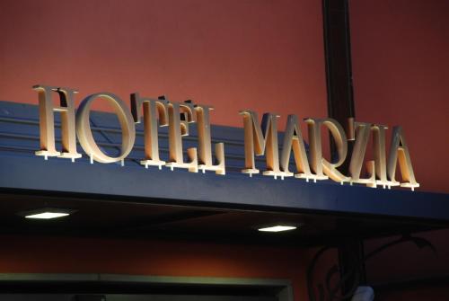 a neon sign for a louis vuitton store at Hotel Marzia in Scandicci
