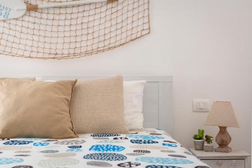 a bed with a comforter on top of it at Il Balconcino nel Vicolo Short Lets in Polignano a Mare