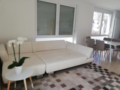 a living room with a white couch and a table at Gemütliches 3 Zimmer Apartment nahe Graz in Gratkorn