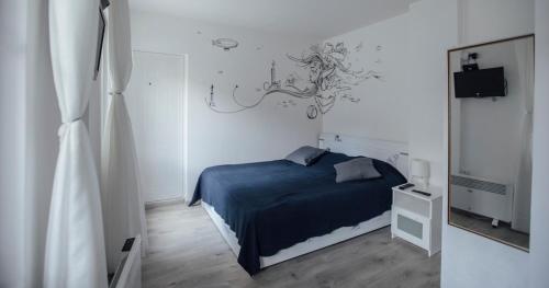 1 dormitorio con cama azul y espejo en Molders Apartments, en Belgrado