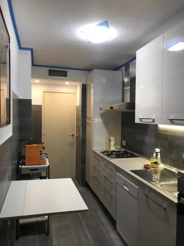 une cuisine avec des armoires blanches et un four à plaques de cuisson dans l'établissement Menton smartworking and relax on the beach, seaview, à Menton