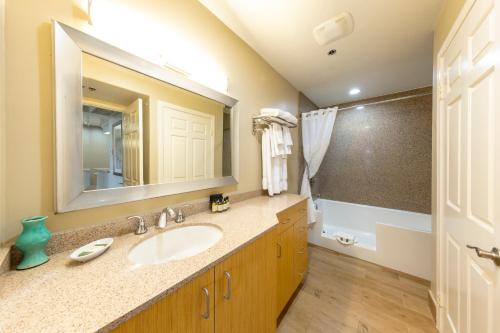 W łazience znajduje się umywalka i lustro. w obiekcie Capistrano SurfSide Inn w mieście Capistrano Beach