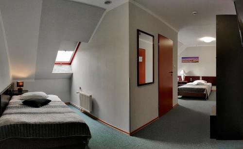 a bedroom with two beds and a cat laying on the bed at Hotel Pawłowski in Zgorzelec