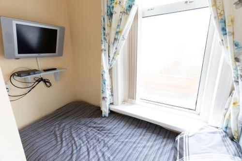 an empty room with a window and a tv at The Osprey Hotel in Blackpool