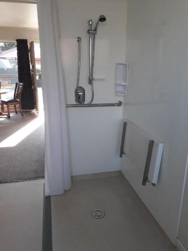 Habitación con baño blanco con ducha. en Aalton Motel Temuka en Temuka
