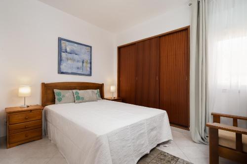 1 dormitorio con 1 cama grande y armario de madera en Aurorasol Carvoeiro Beach Apartment, en Carvoeiro