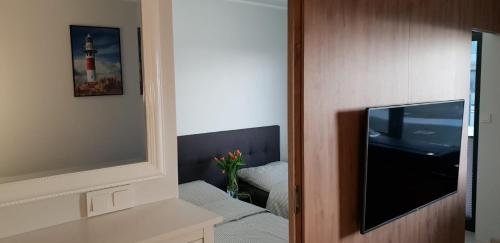 sala de estar con TV y sofá en OPAL z widokiem na morze w Gardenia Sea Side Dziwnów en Dziwnów