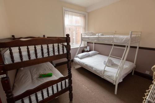 a bedroom with two bunk beds and a window at The Riviera Hotel in Blackpool