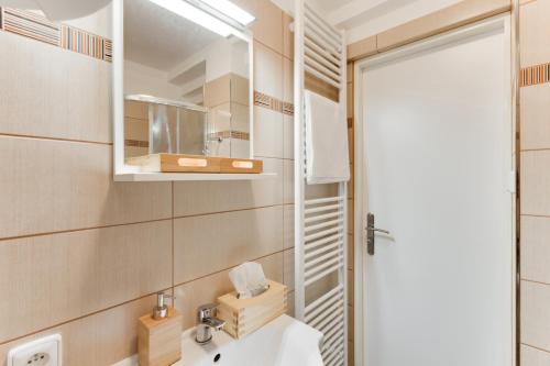 ein Bad mit einem Waschbecken und einem Spiegel in der Unterkunft JT's Apartments Navrátilova str. in Prag