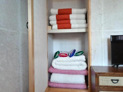 a stack of folded towels in a closet at Mirinae Hanok Tradiational House in Gwangyang