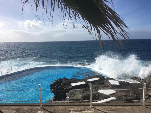 una piscina junto al océano con una ola estrellada en queen’s paradise, en Callao Salvaje
