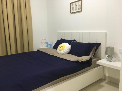a bed with a smiley face pillow on it at Woodsbury Suites 7722 Butterworth Penang in Butterworth