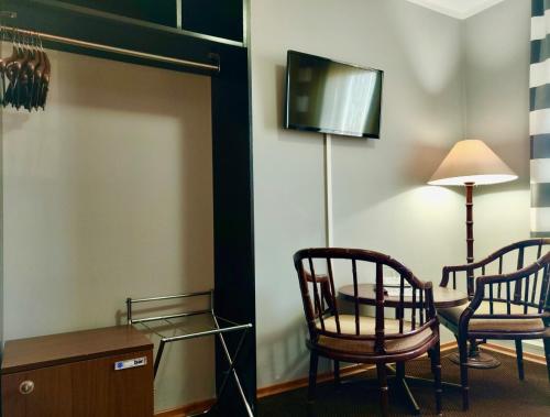 a room with two chairs and a table and a lamp at Hotel Pawłowski in Zgorzelec