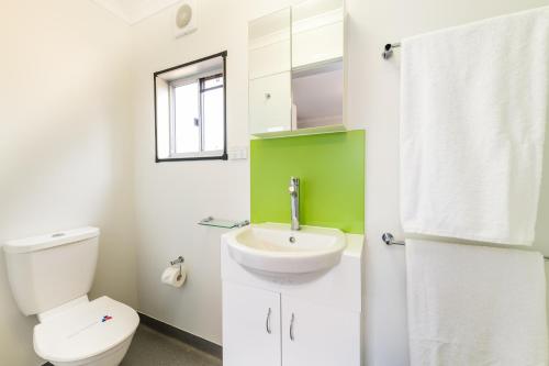 Łazienka z białą toaletą i umywalką w obiekcie Jolly Swagman Acccommodation Park w mieście Toowoomba