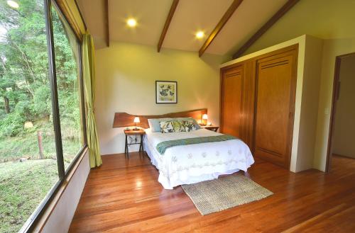 a bedroom with a bed and a large window at Monteverde Casa Mia, near main attractions and town! in Monteverde Costa Rica