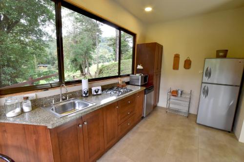 Monteverde Casa Mia, near main attractions and town! في مونتيفيردي كوستاريكا: مطبخ مع مغسلة وثلاجة ونافذة