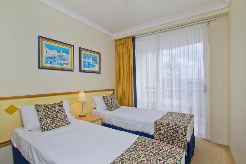 a hotel room with two beds and a window at Palazzo Colonnades in Gold Coast