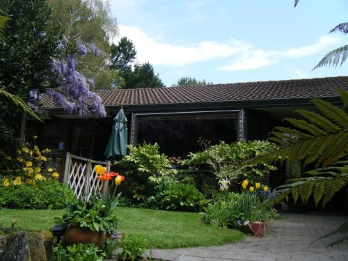 a garden in front of a house with flowers at TWYNHAM at Kinloch in Kinloch