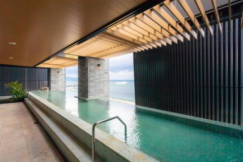 uma piscina num edifício com vista para o oceano em REX HOTEL Beppu em Beppu
