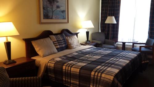 a hotel room with a bed and a chair at Travel Inn in Duffield
