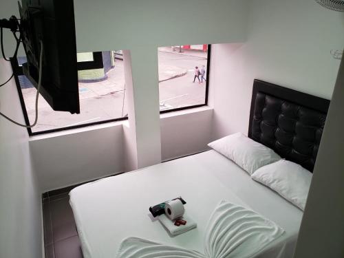 una cámara sentada en una cama en una habitación en Hotel zona express sandiego, en Medellín