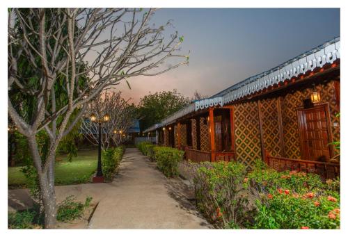a building with a pathway in front of a yard at Ruby True Hotel in Bagan