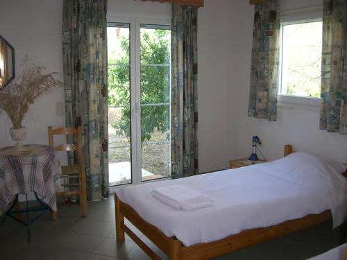 een slaapkamer met een bed en een groot raam bij NIKOS in Kakóvatos