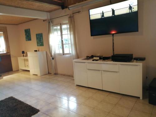 a living room with a television on the wall at VILLA LA KAZ PAYET in Rivière