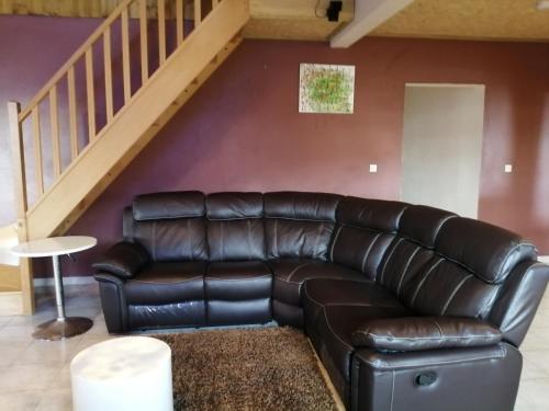 a leather couch in a living room with a staircase at VILLA LA KAZ PAYET in Rivière