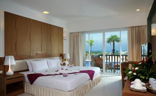 a bedroom with a large bed and a view of the ocean at Princess Seaview Resort & Spa - SHA Plus in Karon Beach