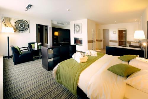 a hotel room with a large bed and a living room at Hotel Charleroi Airport - Van Der Valk in Charleroi