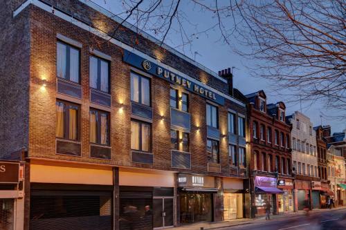 a brick building with a sign on it on a street at Putney Hotel in London