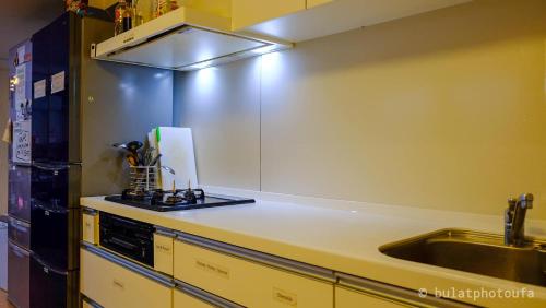 a kitchen with a sink and a counter top at Peace House Suzunami in Osaka