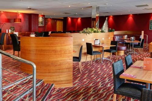 a restaurant with tables and chairs and red walls at Best Western Kings Manor in Edinburgh