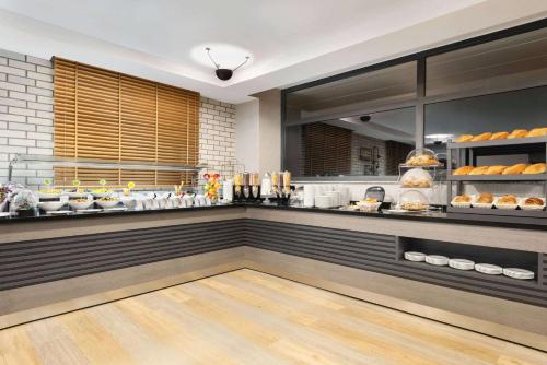 a restaurant kitchen with a counter with food at Ramada By Wyndham Tire in Tire