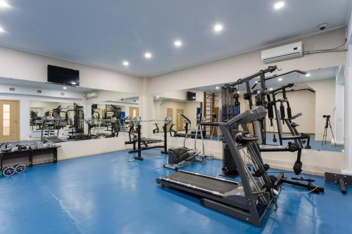 a gym with treadmills and machines in a room at Evropa Hotel in Bishkek