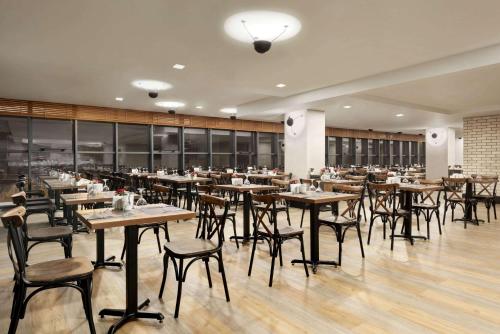 a dining room with wooden tables and chairs at Ramada By Wyndham Tire in Tire