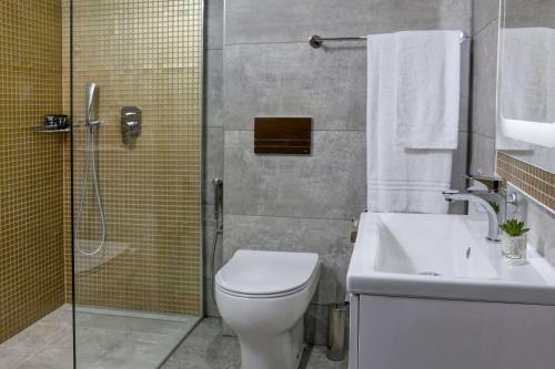 a bathroom with a shower and a toilet and a sink at Putney Hotel in London