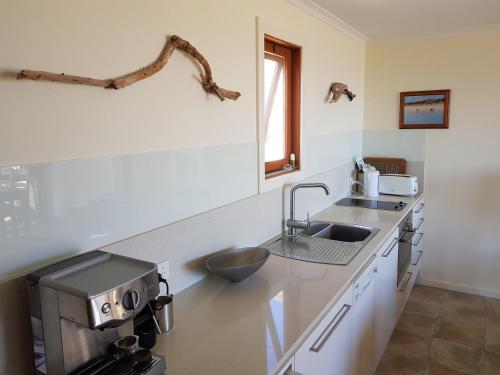 tu Emuz Stone Beachfront Villa, Emu Bay, Kangaroo Is في Emu Bay: مطبخ مع حوض و كونتر توب