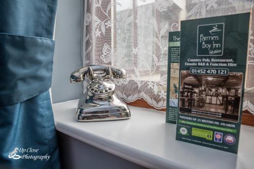 a silver telephone sitting on a window sill next to a box at The Farmers Boy Inn Guest House in Longhope