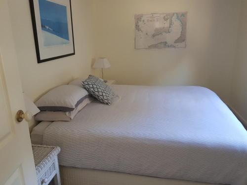 a bedroom with a white bed with a lamp at tu Emuz Stone Beachfront Villa, Emu Bay, Kangaroo Is in Emu Bay