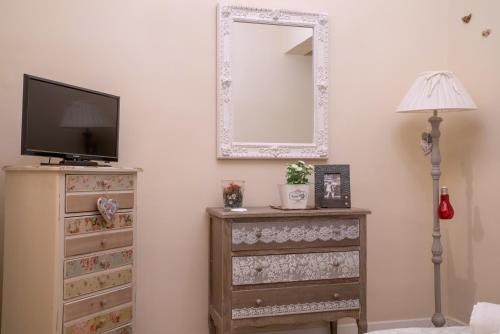 a room with a television and a dresser with a mirror at Art de vivre in Sorrento