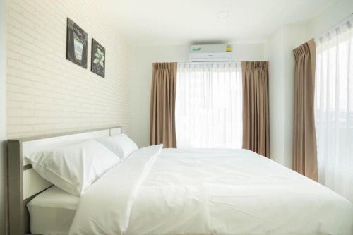 a bedroom with a white bed and a window at The Lux Ladprao 10 in Bangkok