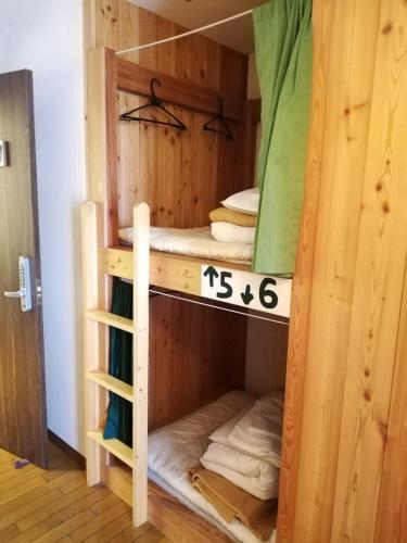 a bunk bed in a wooden room at The Evergreen Hostel 長期ステイ歓迎 エバーグリーンホステル in Hiroshima