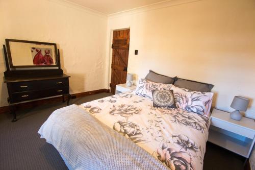 a bedroom with a bed with a clock on it at Old Swanport General Store, Swanport-Murray River in Swanport